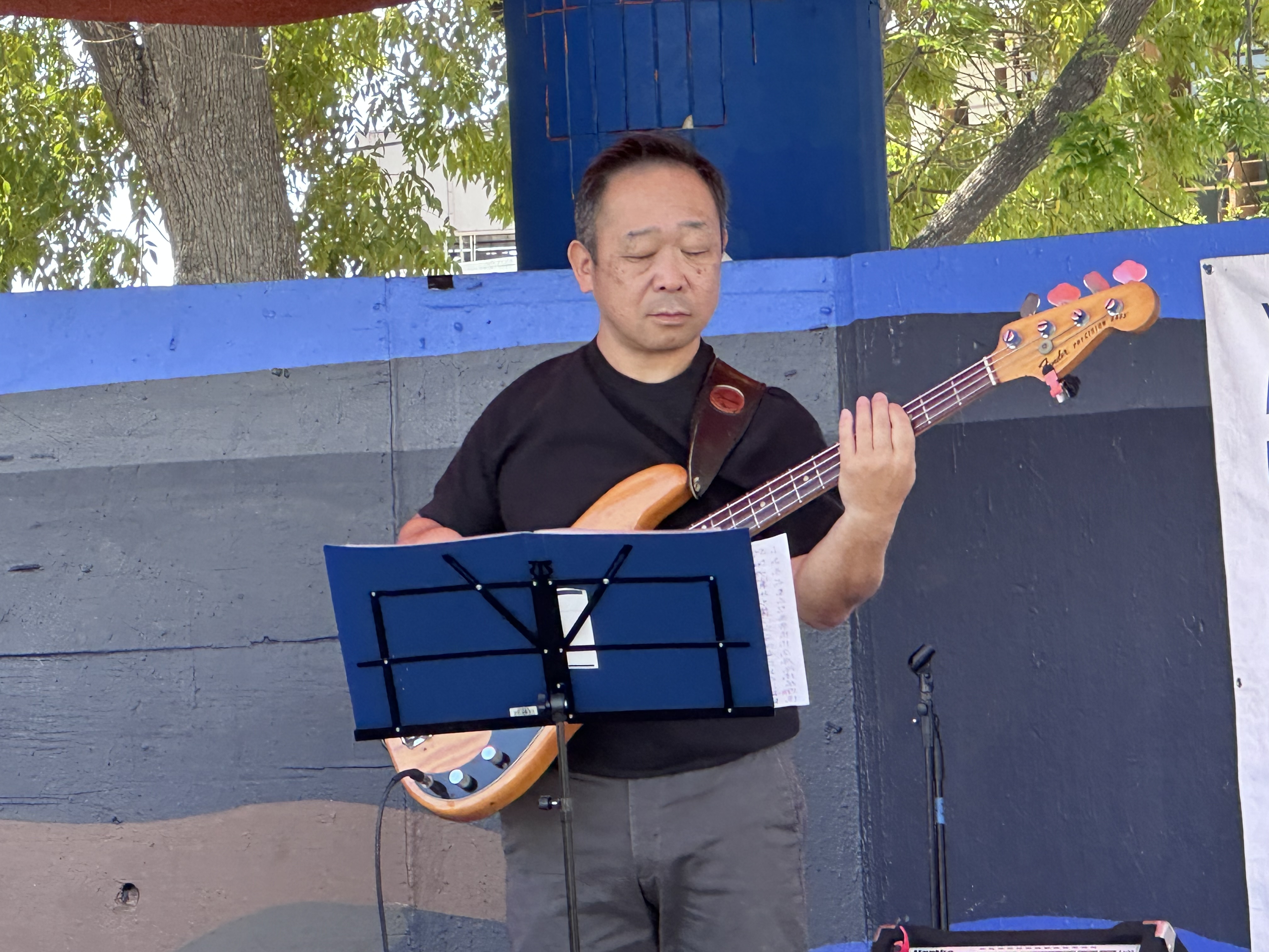 Musician performing with bass guitar at a J-Collective gathering.